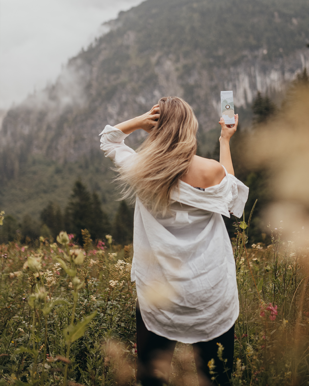 Woman in field holding product