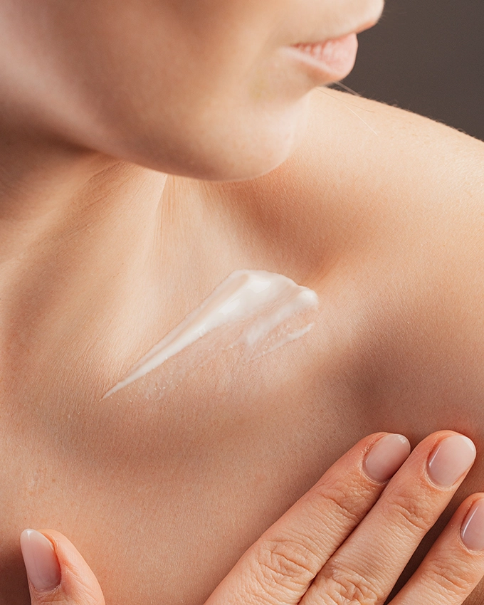 Woman applies Trawenmoor skin care to her décolleté