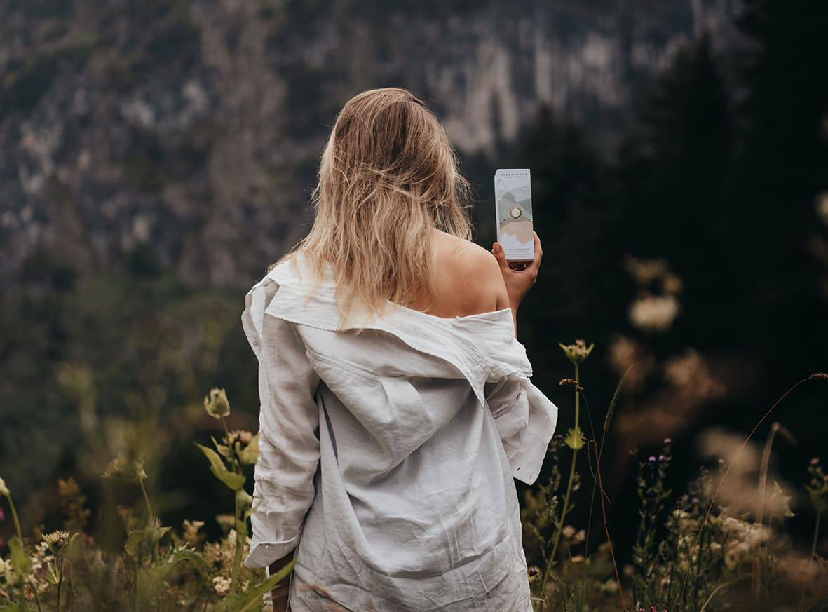 Frau hält Trawenmoor Hautpflegeprodukt in der Hand in der Natur
