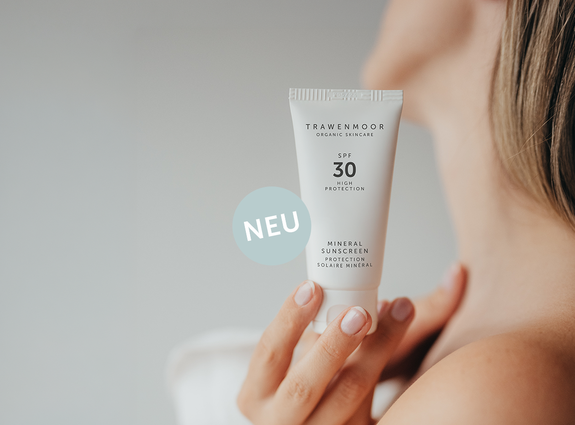 Frau mit Sonnenscreme in der Hand